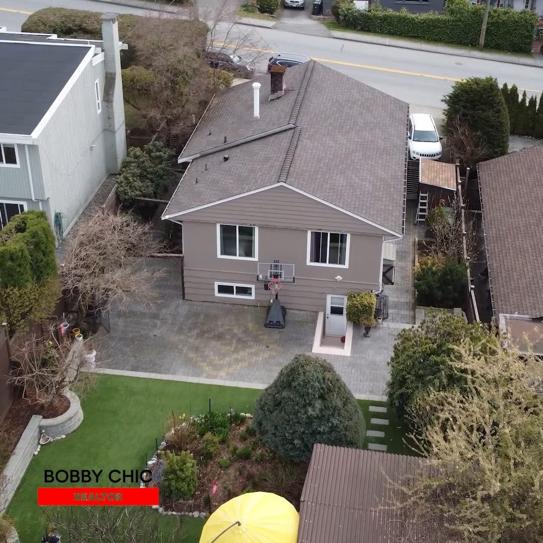 Aerial view of a detached residential home, backyard, roof and surrounding neighbourhood