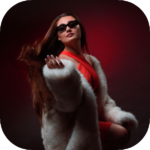 Woman posing in a red dress against a dark background with dramatic studio lighting.
