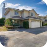 Large residential house with balconies, attached garage and landscaped frontage.