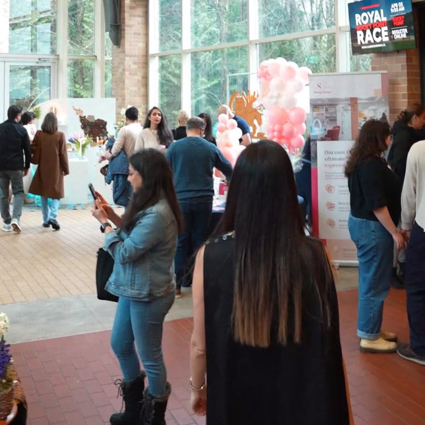 Indoor event scene showing several formally dressed guests standing together and socializing inside a busy venue.