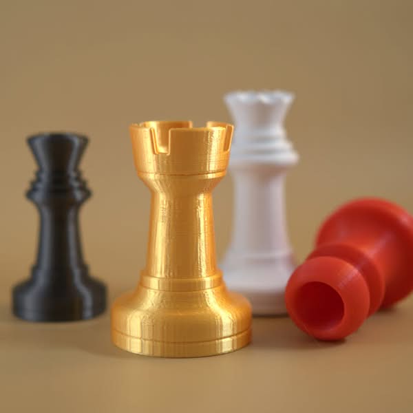 Colourful hollow chess pieces made with 3D printing and designed to function as drinking shot glasses.