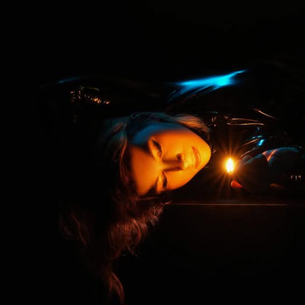 Abstract low light glamour portrait illuminated with warm orange and cool blue light