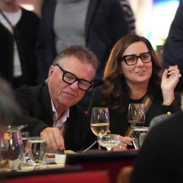 Smiling couple seated together at a formal dinner table during an evening event