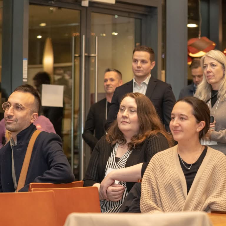 Conference attendees seated at tables and listening during a professional indoor event in Vancouver