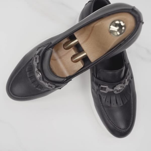 Pair of black leather dress shoes arranged together on a clean white background for commercial photography