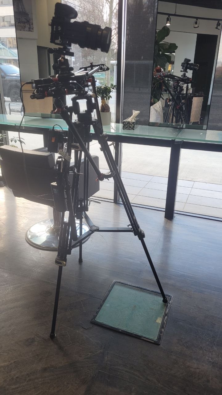 Professional video camera on a tripod and slider during a commercial shoot in a hair salon